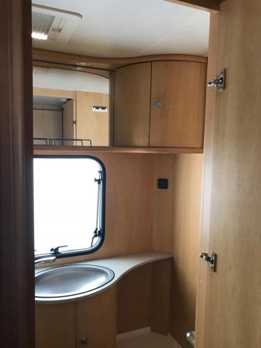 a small bathroom with a sink and a window at Domek, caravaning nad jeziorem, Giże in Giże