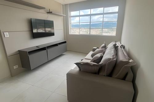 a living room with a couch and a television at Cobertura magnifica in São Roque