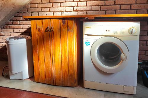 una lavadora junto a un armario de madera en La Casita de Paso de los Andes, Mendoza, en Mendoza