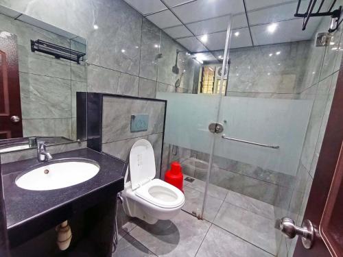 a bathroom with a toilet and a sink and a shower at FLORA INN Gokarna in Gokarna