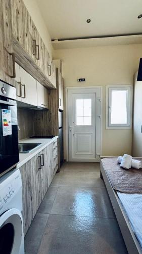 a kitchen with wooden cabinets and a white appliance at Kotronia Suites in Skiathos Town