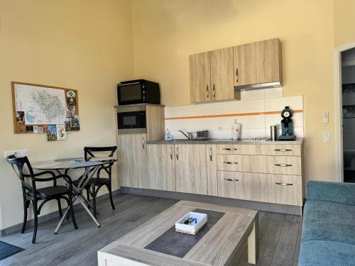 a kitchen with a table and a dining room at Gîte Relais du Doulay in Saint-Fulgent