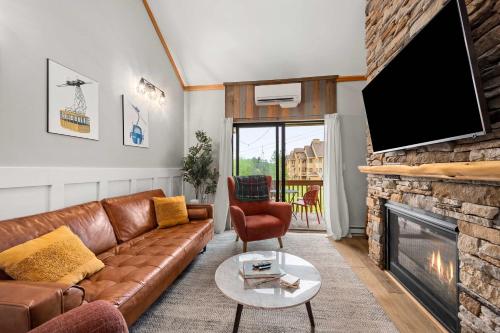 a living room with a couch and a fireplace at Renovated Ski In Out Condo King Bed Patio Grill in Ellicottville