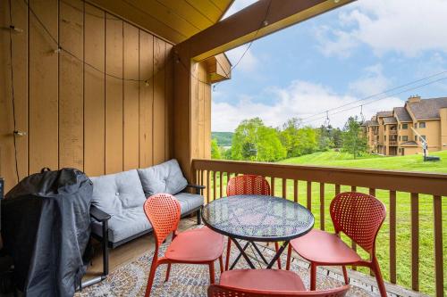 a balcony with a table and chairs and a couch at Renovated Ski In Out Condo King Bed Patio Grill in Ellicottville