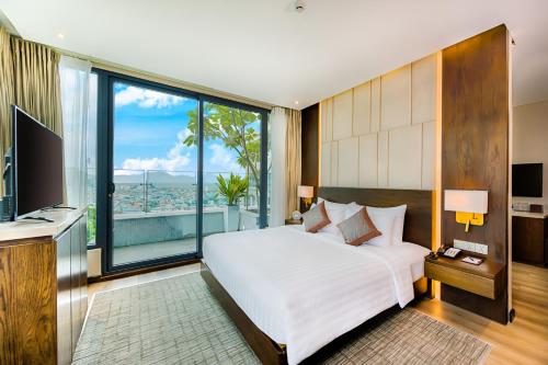 a bedroom with a large white bed and a large window at New Orient Hotel Da Nang in Da Nang