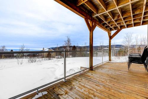 una terraza cubierta con nieve en el suelo en Le Huppe - Spa Ski & River View, en Petite-Rivière-Saint-François
