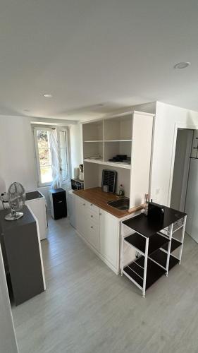 モントルーにあるLogement entier Montreuxの白いキャビネットとカウンタートップを備えたキッチン