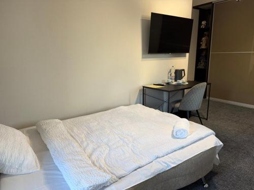 a bedroom with a bed and a desk with a television at Aero Hotel in Chişinău