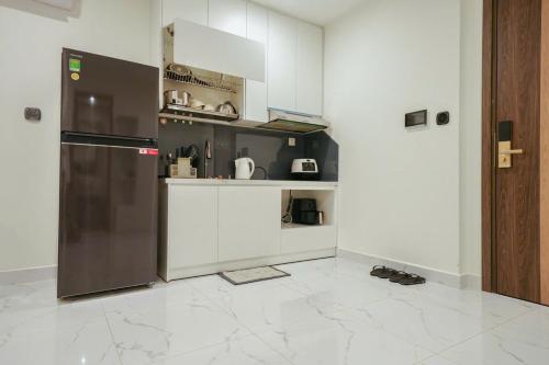 a kitchen with white cabinets and a stainless steel refrigerator at CĂN HỘ VINHOMES GRAND PARK QUẬN 9 Studio in Gò Công