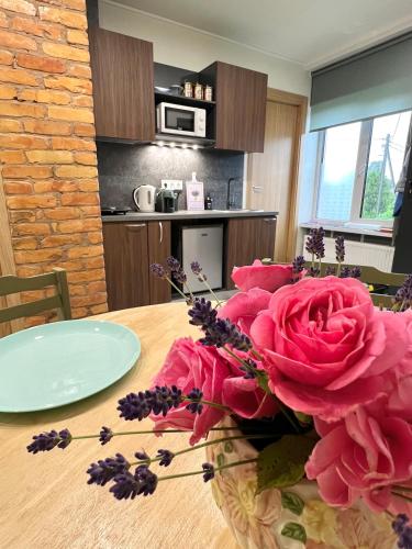 a table with pink roses on it in a kitchen at Apartment Vainagu street Sigulda in Sigulda