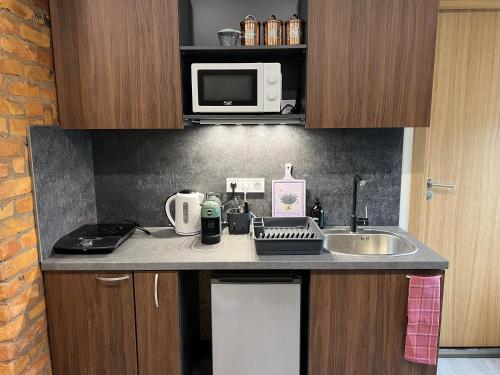 a small kitchen with a sink and a microwave at Apartment Vainagu street Sigulda in Sigulda