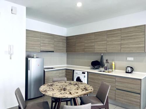 シャー・アラムにあるRustic Homes at i-City - WiFi TV Box 1 Carparkのテーブルと冷蔵庫のあるキッチン