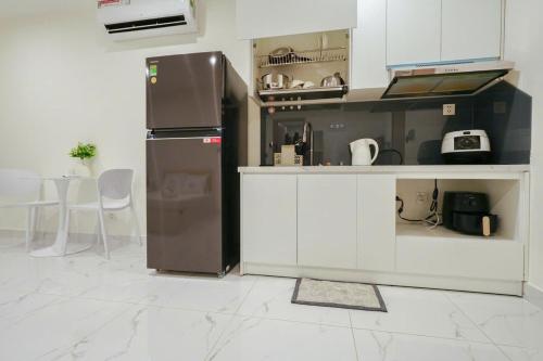 a kitchen with a refrigerator and a table and chairs at CĂN HỘ VINHOMES GRAND PARK QUẬN 9 Studio in Gò Công