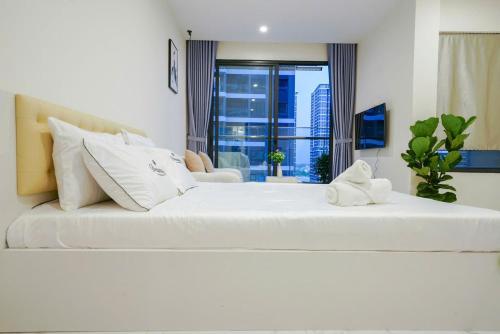 a large white bed in a room with a window at CĂN HỘ VINHOMES GRAND PARK QUẬN 9 Studio in Gò Công