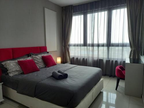 a bedroom with a bed with a red headboard and red pillows at Phenom Homes at i-City - WiFi TV Box 1 Carpark in Shah Alam