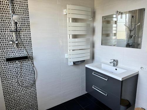 a white bathroom with a sink and a shower at Gîte Relais du Doulay in Saint-Fulgent