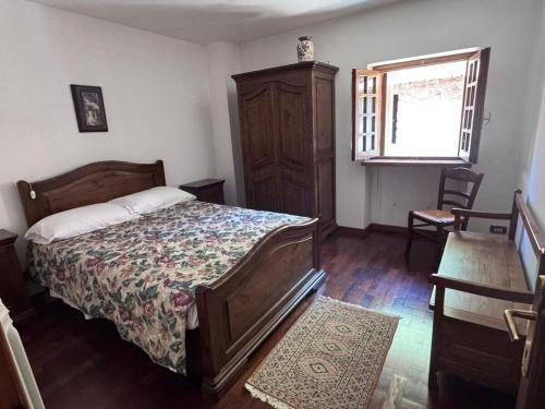 a bedroom with a bed and a dresser and a window at Casetta con camino in centro in Pescasseroli