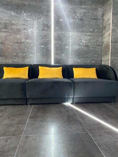 a blue couch with two yellow pillows in a room at Luna Apartments C in Suceava