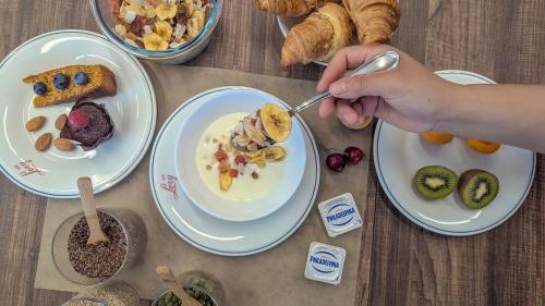 a person eating food on a table with plates of food at Hotel Lory My Wellness SPA in Chianciano Terme