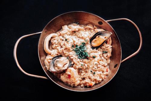 a pan filled with rice and seafood on a table at Hotel Euzko Alkartasuna in Macachín