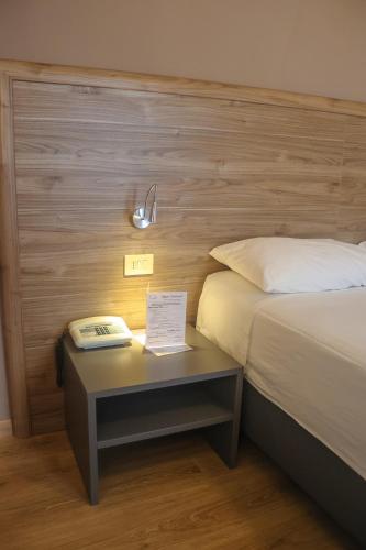 a hotel room with a bed and a table with a phone at Hotel Lory My Wellness SPA in Chianciano Terme