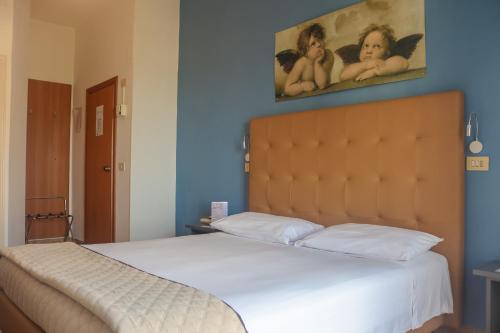 a bedroom with a bed with a painting on the wall at Hotel Lory My Wellness SPA in Chianciano Terme