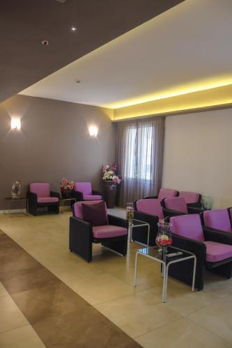 a waiting room with purple chairs and tables at Hotel Lory My Wellness SPA in Chianciano Terme