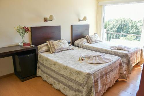a hotel room with two beds and a window at Hotel Euzko Alkartasuna in Macachín