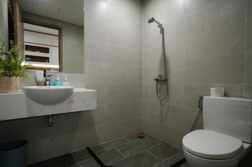 a bathroom with a shower and a toilet and a sink at CĂN HỘ VINHOMES GRAND PARK QUẬN 9 Studio in Gò Công