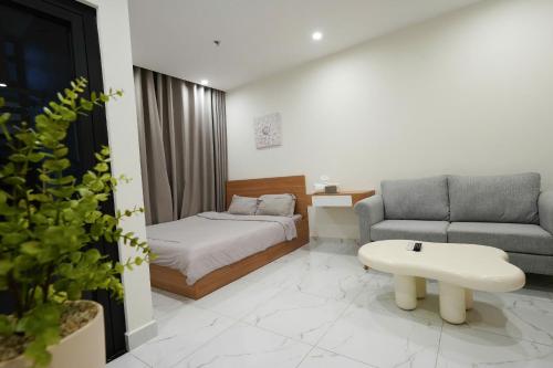 a living room with a bed and a couch at CĂN HỘ VINHOMES GRAND PARK QUẬN 9 Studio in Gò Công