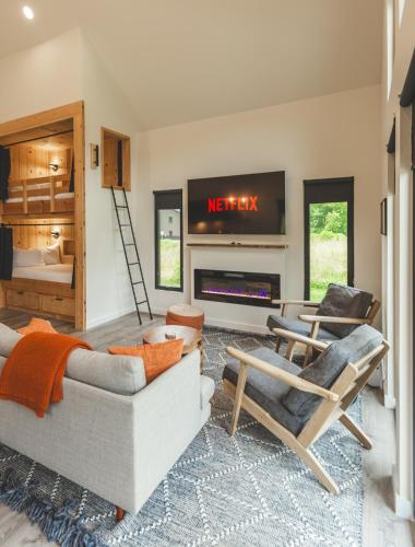 a living room with a couch and chairs and a tv at NEW! Moonrise Meadow | Hot Tub | River | 360 Views in Stanton