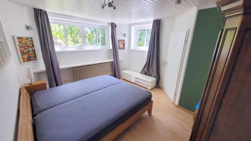 a bedroom with a blue bed and two windows at Urlauber und Monteure willkommen in Baesweiler