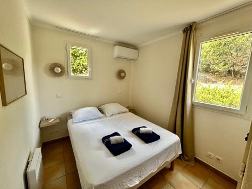 una camera da letto con un letto con cuscini blu di Les Restanques Bruyeres 2001 proche piscine a Grimaud