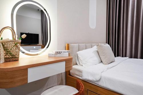 a small bedroom with a mirror and a bed at CĂN HỘ VINHOMES GRAND PARK QUẬN 9 Studio in Gò Công
