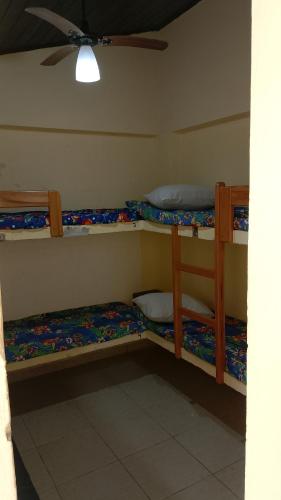 a room with three bunk beds in it at Pousada Angelical in Saquarema