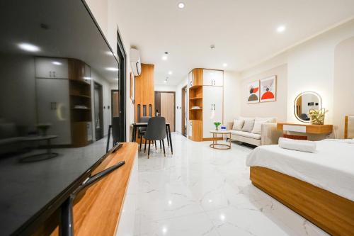 a bedroom with a bed and a living room at CĂN HỘ VINHOMES GRAND PARK QUẬN 9 Studio in Gò Công