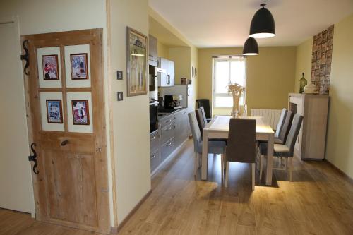 a kitchen and dining room with a table and chairs at Aux Pierres Magiques in Saint-Laurent-de-Chamousset