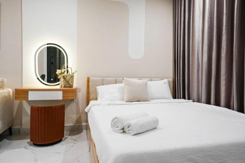 a bedroom with a bed with two towels on it at CĂN HỘ VINHOMES GRAND PARK QUẬN 9 Studio in Gò Công