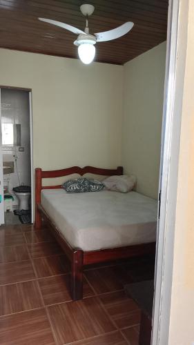 a bed in a room with a ceiling fan at Pousada Angelical in Saquarema