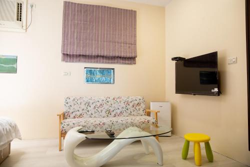 un salon avec une chaise et une table dans l'établissement 礁溪-泡在田裡-溫泉包棟民宿, à Jiaoxi