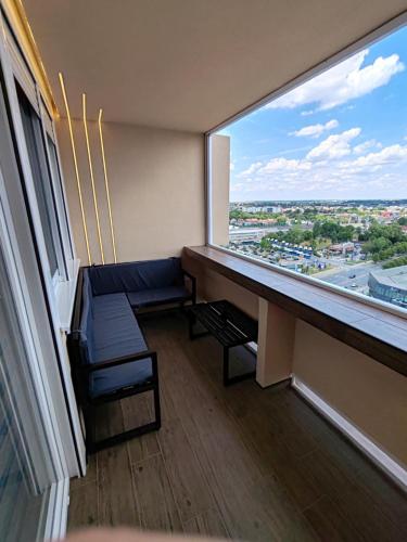 a room with a couch and a large window at Princ lux spa with sauna and jacuzzi in Novi Sad