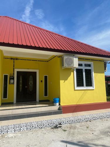 a yellow and red house with a red roof at WIDADD HOMESTAY Kuala Selangor in Kuala Selangor