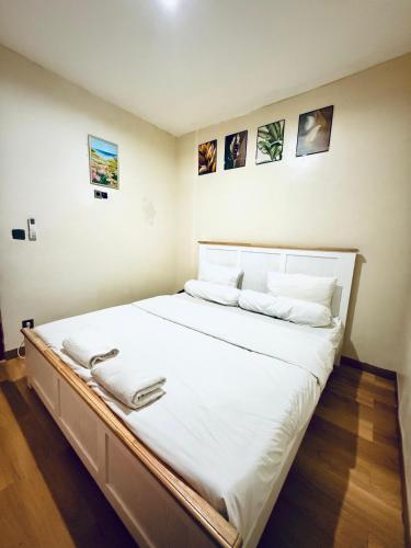 a bedroom with a large bed with white sheets at Homestay Room near Kuta & Legian Beach Bali in Pesanggaran