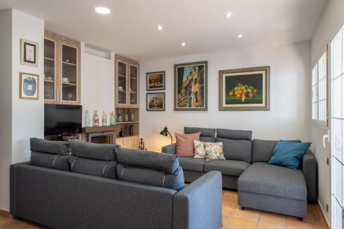 ein Wohnzimmer mit Sofa und Fernseher in der Unterkunft Ragon Residencial, 11 in Güéjar-Sierra