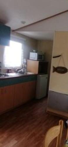 une cuisine avec un évier et un plan de travail dans l'établissement mobil home 9, à Beaugeay