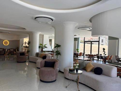 a living room with couches and chairs and tables at Ailana Hotel in Aqaba