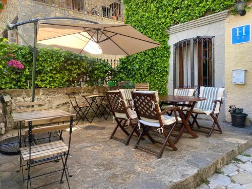 a patio with a table and chairs and an umbrella at Hotel Casa Socotor in Sallent de Gállego