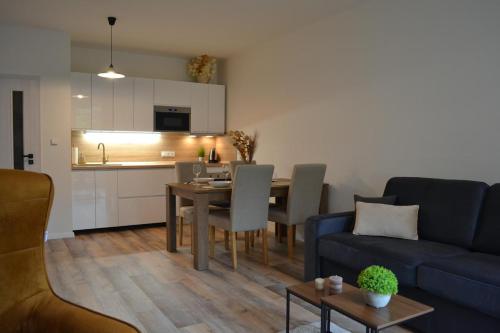 a living room with a table and a blue couch at Apartmán u Fontány 2-free parking in Poděbrady