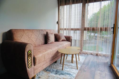 a living room with a brown couch and a table at HANA Superior Apartment in Kakanj