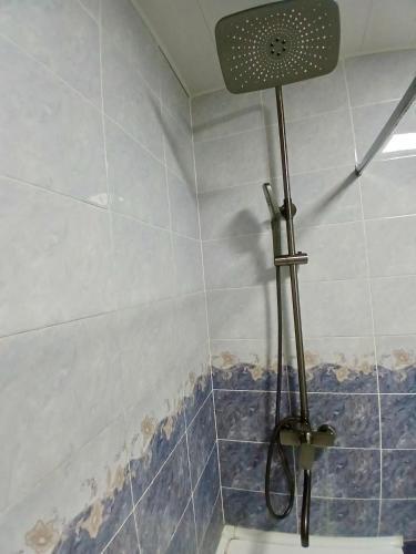 a shower in a bathroom with blue and white tiles at Квартира 2 х комнатная in Dushanbe